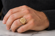 Men’s 14K gold family crest signet ring worn on hand